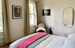 a bedroom with a bed and a mirror and a chair at Norwood in Rushbrooke