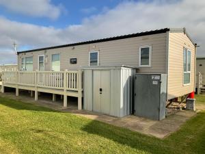 a mobile home with a porch and a fence at Konies Place Golden Anchor Free WiFi Bedding Included in Chapel Saint Leonards