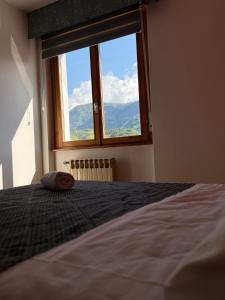 a bedroom with a bed with a large window at Hotel Mezzolago in Calceranica al Lago