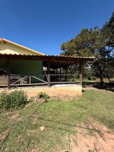 a building with a roof on the side of a field at Rancho dos dourados in Três Marias