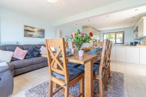 a kitchen and living room with a wooden table and chairs at Ty-Mari in Harlech
