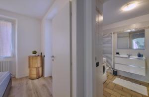 a bedroom with a bed and a sink and a mirror at In centro Ca' Leandro Vista lago in Lierna