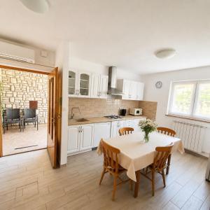a kitchen and dining room with a table and chairs at Apartments Renato Mužić Cres in Cres