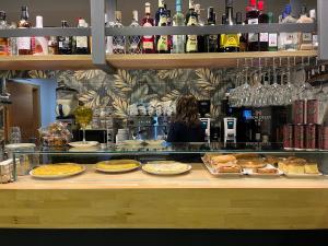 a woman standing behind a counter with food on display at Hotel Casa Azcona in Zizur Mayor