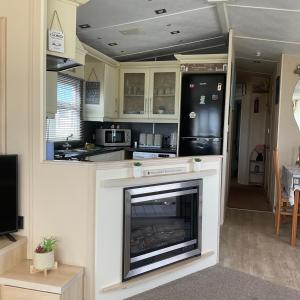 a living room with a fireplace in a kitchen at Konies Place Golden Anchor Free WiFi Bedding Included in Chapel Saint Leonards +20 photos