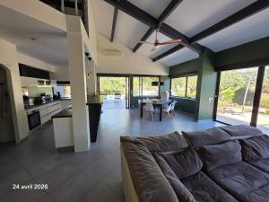 a large living room with a couch and a kitchen at Spacieuse villa au calme avec grande piscine in Bormes-les-Mimosas