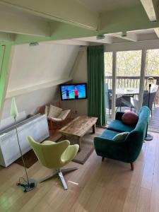 a living room with a couch and a tv at Boshuis Green Forest in Durbuy