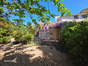 a house with purple flowers on the side of it at Spacieuse villa au calme avec grande piscine in Bormes-les-Mimosas