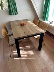 a dining room table with a bowl of oranges on it at Boshuis Green Forest in Durbuy +12 photos