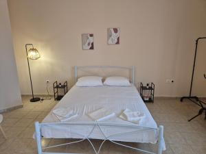 a white bed in a room with two pictures on the wall at Airport city center 2 in Spata