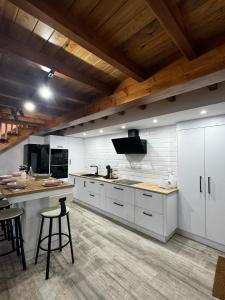a large kitchen with white cabinets and wooden ceilings at Casa Erundina in Camariñas