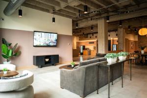 a living room with a couch and a tv on the wall at Roami at Century Plaza in Minneapolis