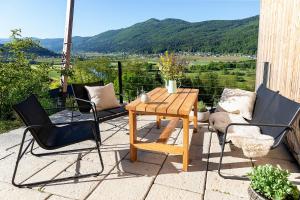 Ein Tisch und Stühle auf einer Terrasse mit Aussicht in der Unterkunft Riverview cabin in Straža + 11 Fotos