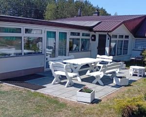 a picnic table and benches in front of a house at Domek Agroturystyczny Doris in Stężyca
