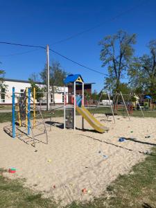 a playground with a slide in the sand at Dunaparti Kuckó in Kiskunlacháza