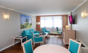 a hotel room with blue chairs and a table at Hollywood Media Hotel am Kurfürstendamm in Berlin