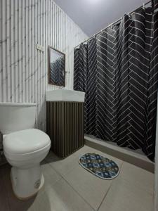 a bathroom with a toilet and a black and white wall at Carms Villa Resort in Kidapawan