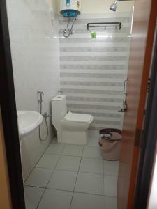 a bathroom with a toilet and a sink at Maruthi inn hotel in Vijayawāda +15 photos