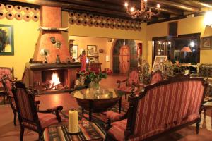 a living room with a fireplace and a table and chairs at Hacienda Leito in Patate