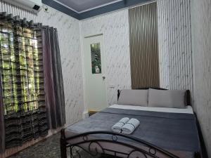 a bedroom with a bed with two slippers on it at Carms Villa Resort in Kidapawan