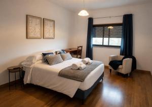 a bedroom with a bed with two towels on it at Entre Ilhas in Horta