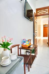 a room with a table with cups and a vase at Nhà nghỉ Việt Mến in Sầm Sơn