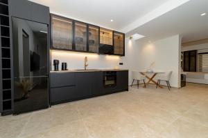 a kitchen with black cabinets and a table at Andromeda Suite Private Jacuzzi & Cave Shower in Athens