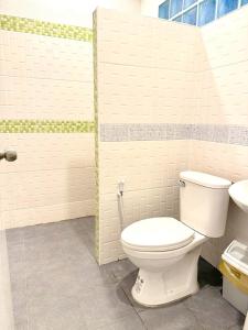 a bathroom with a white toilet and a sink at Full House in Ban Not (1)