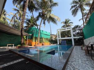 a pool at a resort with palm trees at Aura Calangute in Calangute