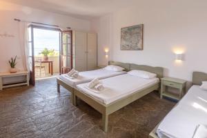 a bedroom with two beds and a balcony at ALKYONI in Skala