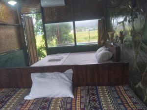 a bedroom with a bed with two pillows and a window at Tràng An Gold in Xuân Sơn
