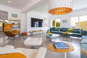 a living room with a blue couch and tables at Villa Aqua Vista in Jávea