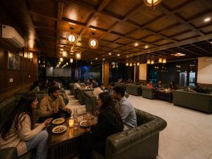 a group of people sitting at a table in a restaurant at Hotel Asiia Holiday with Swimming Pool -Central Heated and Air Cooled, Near mall road in Kasol