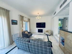 a living room with two couches and a tv at Beach villa Aurelia in Neo Chorio