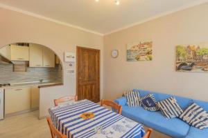 a living room with a blue couch and a table at Casa Azzurra in Portoferraio