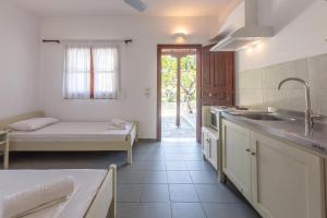 a kitchen with a sink and a bed in a room at ALKYONI in Skala