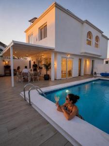 a woman sitting in a swimming pool with a drink at Casa Mer in Tías