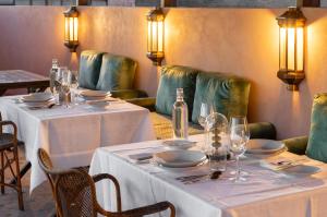a dining room with two tables with plates and glasses at Riad Dar Al Dall - This Time Tomorrow in Marrakech in Marrakesh +42 photos