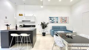 a kitchen and living room with a blue couch at Civico5 - Spazioso appartamento 110 mq a Cefalù in Cefalù