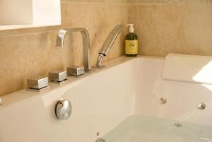 a white bath tub with a sink and a bottle of wine at Il Collina - Poets'Vista in La Spezia