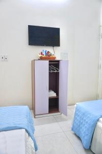 a room with two beds and a tv on a wall at Nhà nghỉ Việt Mến in Sầm Sơn +11 photos
