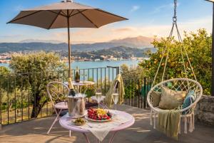 a table with a bowl of fruit and an umbrella at Il Collina - Poets'Vista in La Spezia