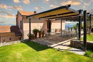 a pergola over a wooden deck in a yard at Il Collina - Poets'Vista in La Spezia +30 photos