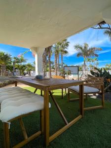 a picnic table and chairs under a white tent at Oasis Dunas Sweet Family Home II Pool view by B-Rent in Corralejo