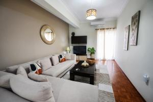 a living room with a white couch and a table at Patithries Apartments in Kalymnos