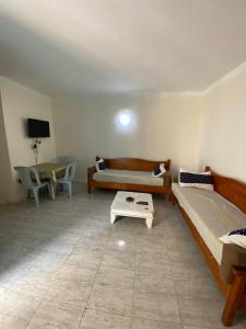 a living room with two beds and a table at Djerba Sérénité in Houmt Souk