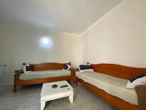 a room with two beds and a table in it at Djerba Sérénité in Houmt Souk