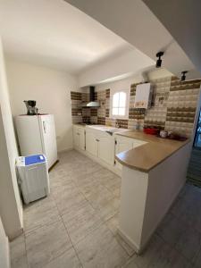 a kitchen with white cabinets and a white refrigerator at Djerba Sérénité in Houmt Souk