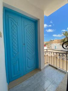 a blue door on a balcony with a view at Djerba Sérénité in Houmt Souk