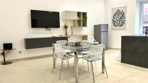 a dining room with a table and chairs and a tv at Civico5 - Spazioso appartamento 110 mq a Cefalù in Cefalù